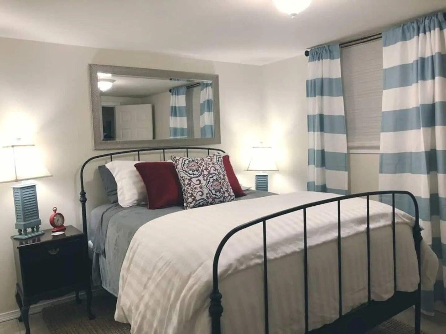 Lower-level queen bedroom with iron bed frame at Magnolia House vacation rental in Bend