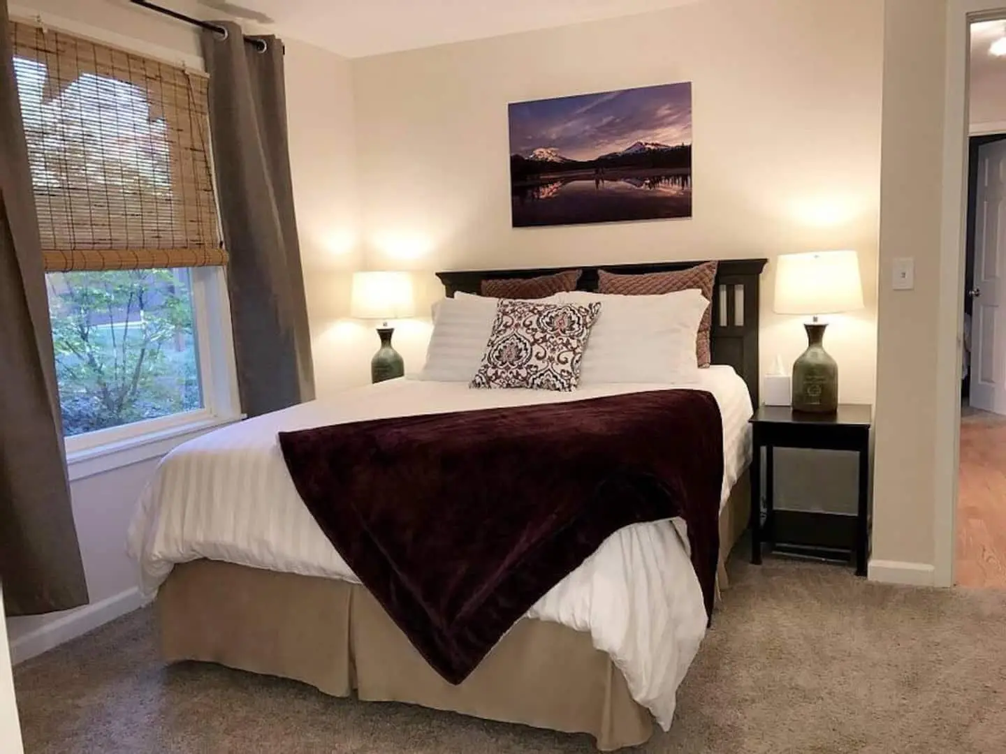 Primary bedroom with queen bed, soft linens, and warm lamps at Magnolia House, Bend, Oregon