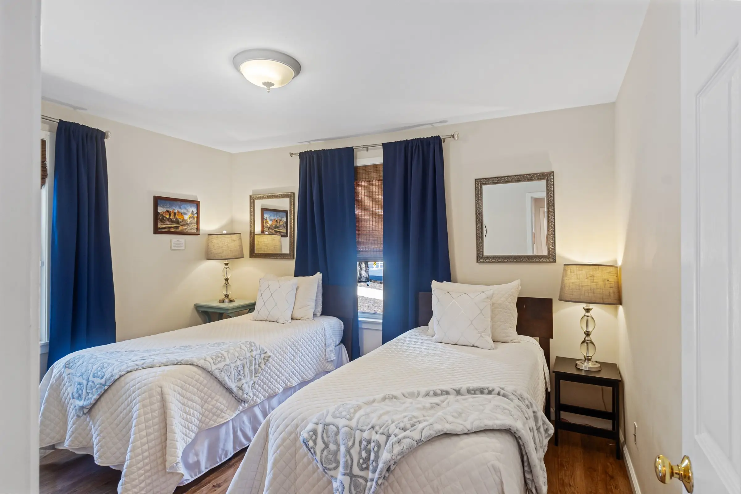 Twin bedroom with two beds and navy curtains at Magnolia House — twins convert to a king on request
