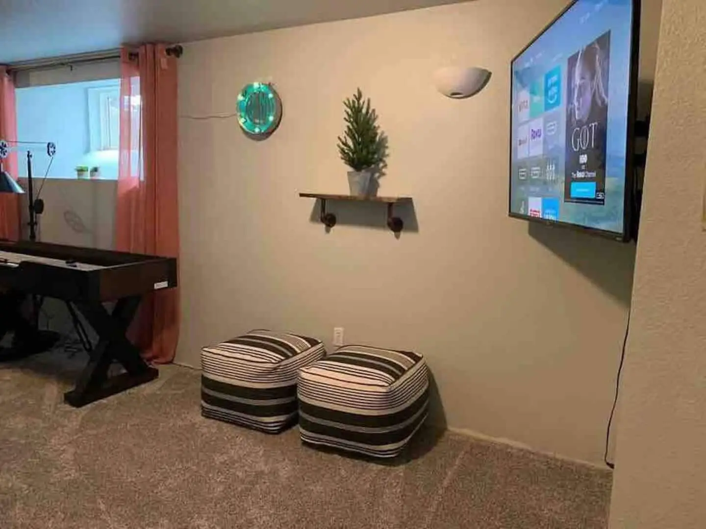 Lower-level den with large smart TV and floor cushions at Magnolia House, Bend