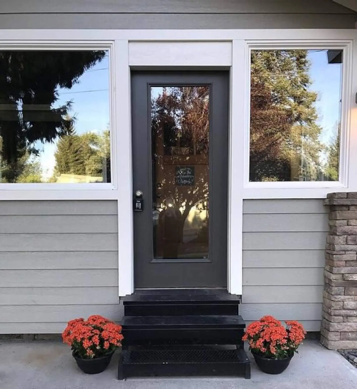 Craftsman front door of Magnolia House with seasonal flowers in Bend’s River West neighborhood