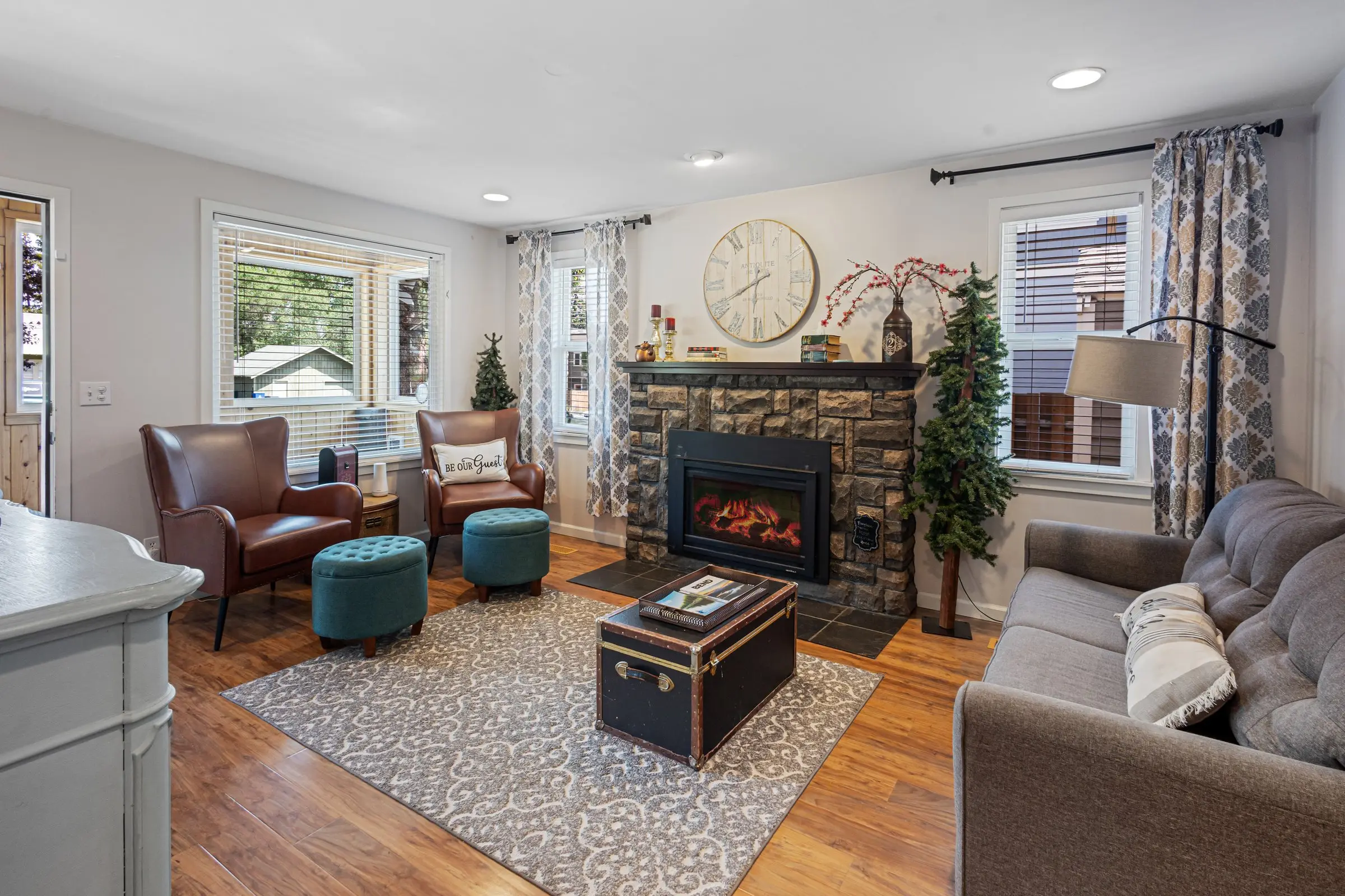 Cozy living room with stone gas fireplace, comfortable seating, and warm decor at Magnolia House in Bend