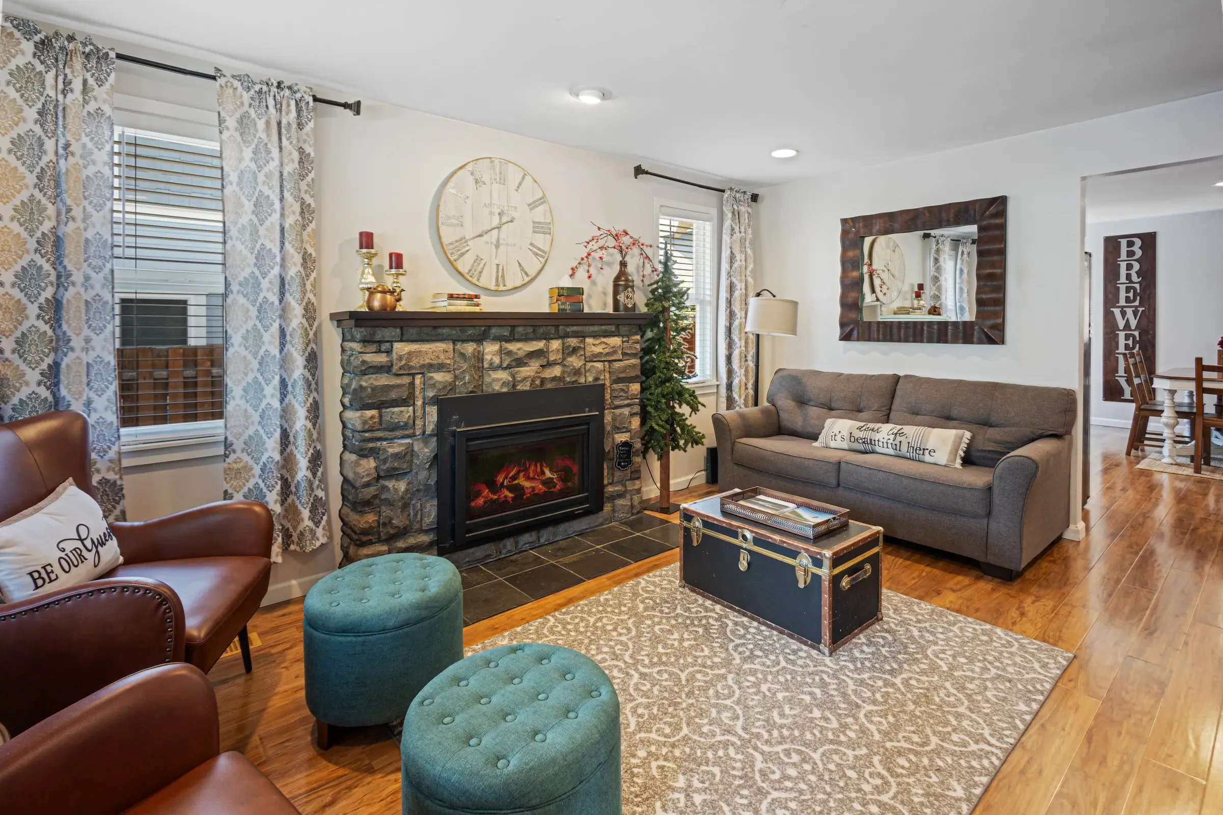 Leather armchairs beside the glowing stone fireplace in the living room of Magnolia House, Bend, Oregon