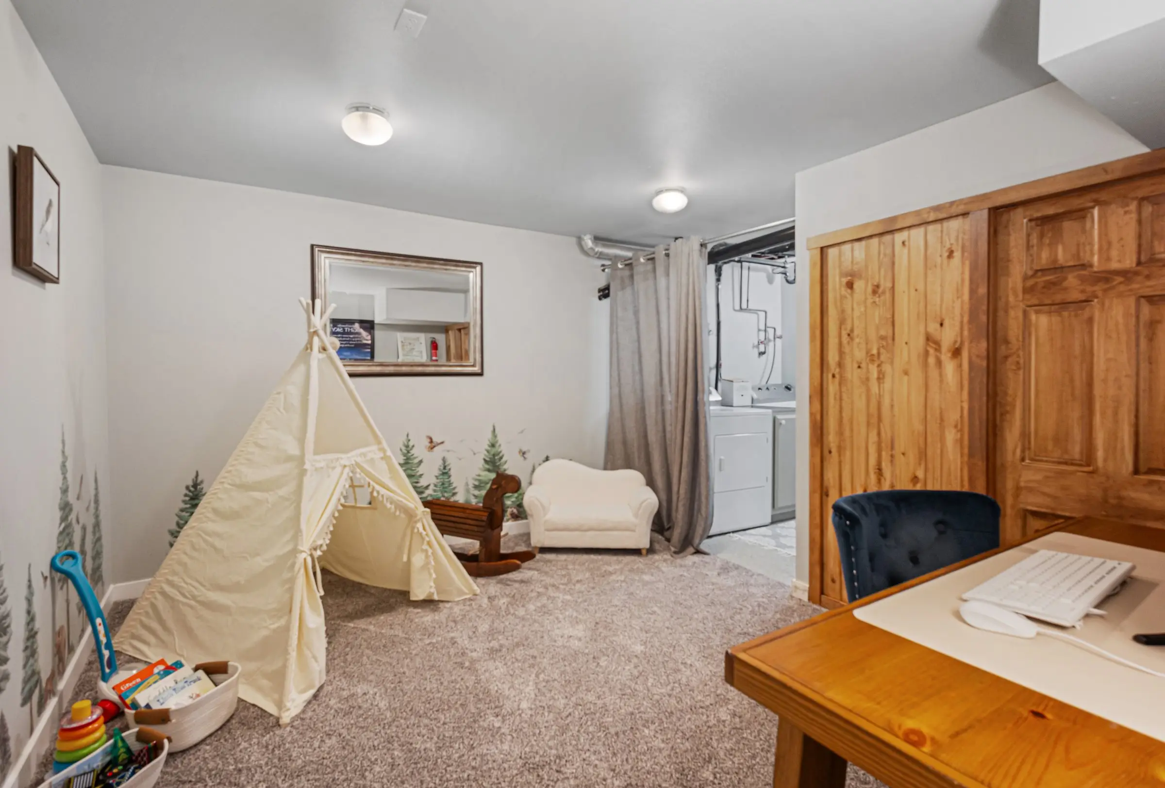 Kids play area with teepee, toys, and books in the lower level of Magnolia House in Bend
